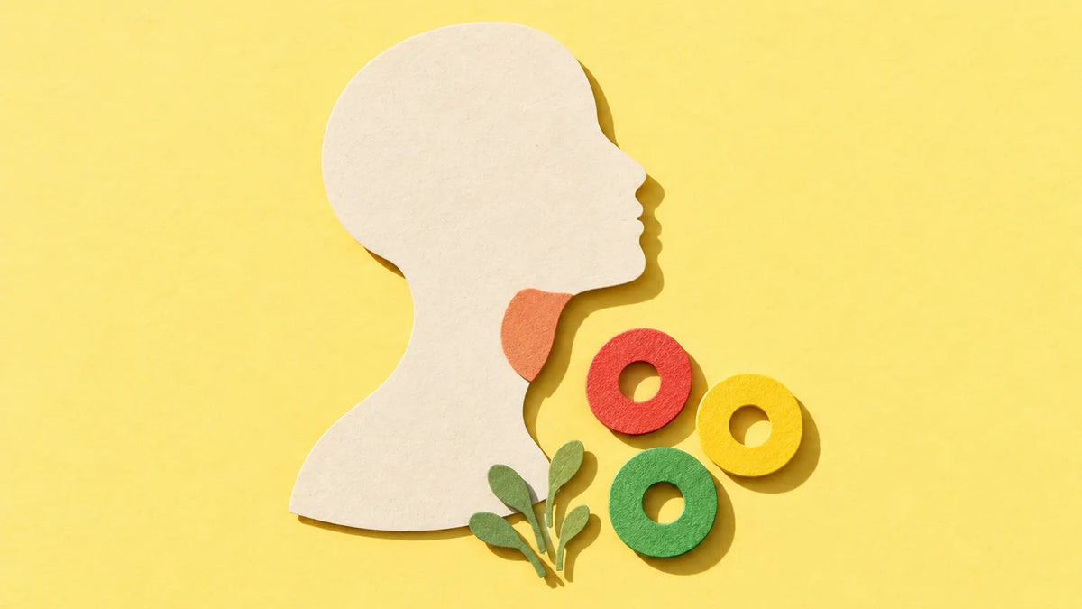 Paper-cut illustration of a head in profile with a warm patch at the throat, beside red, yellow and green sour candy rings on yellow paper