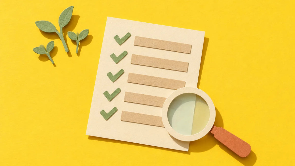 Paper-cut illustration of a checklist under a magnifying glass